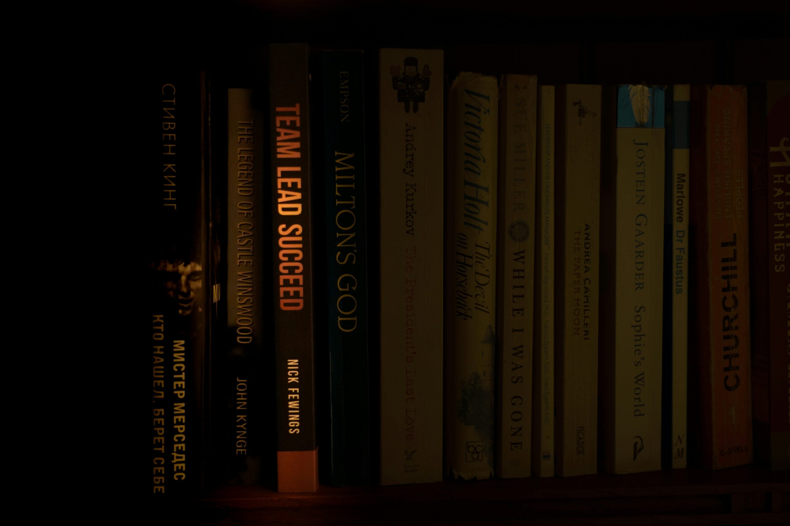 a bookshelf filled with lots of books in a dark room